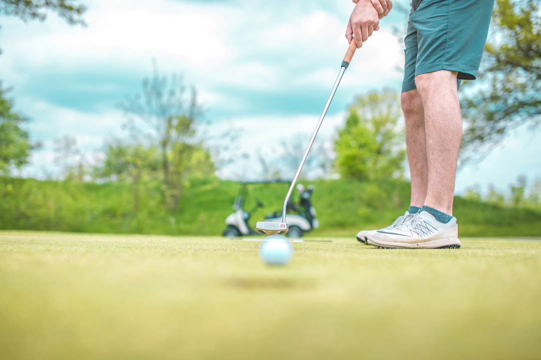 man playing golf under blue sky during daytime