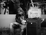 grayscale photography of man sitting on chair