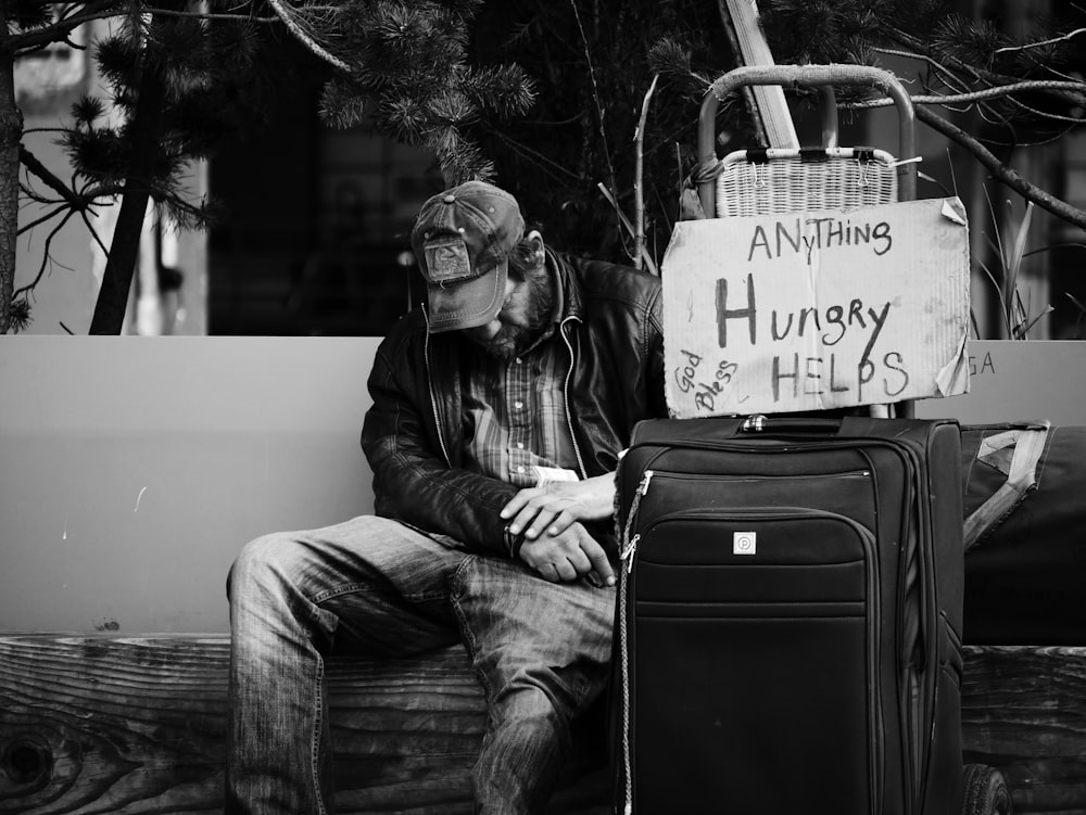 grayscale photography of man sitting on chair