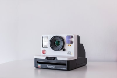 white and black polaroid one step 2 instant camera on white board product zoom background