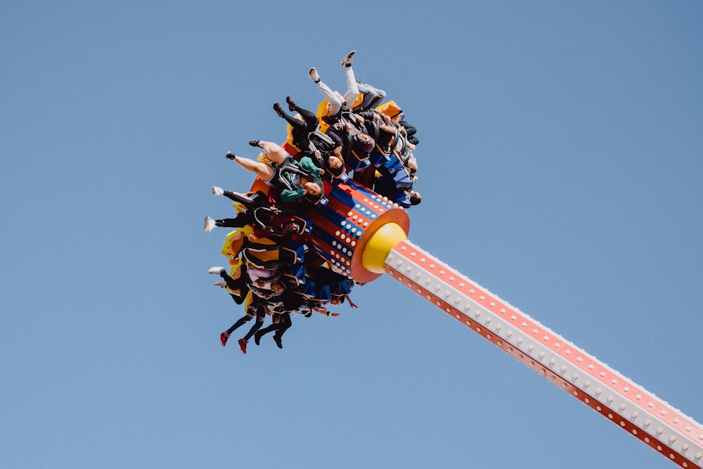 people riding carnival ride under clear blue sky during daytime