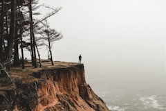 person standing on mountain cliff