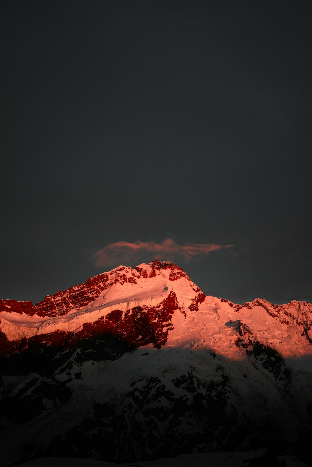 mountain covered in snow under dark sky