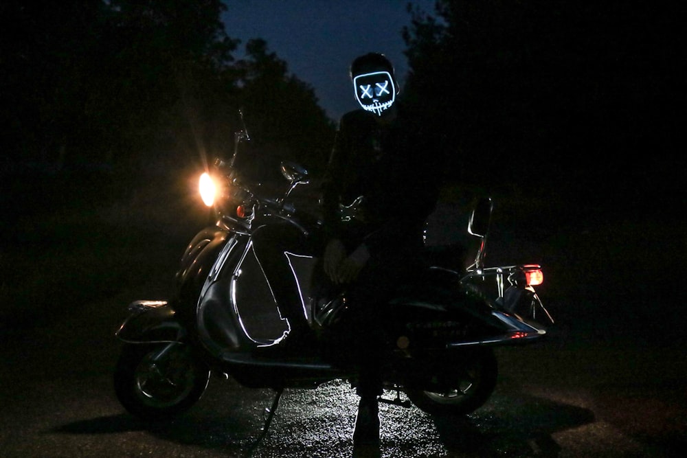 man sitting on gray motor scooter