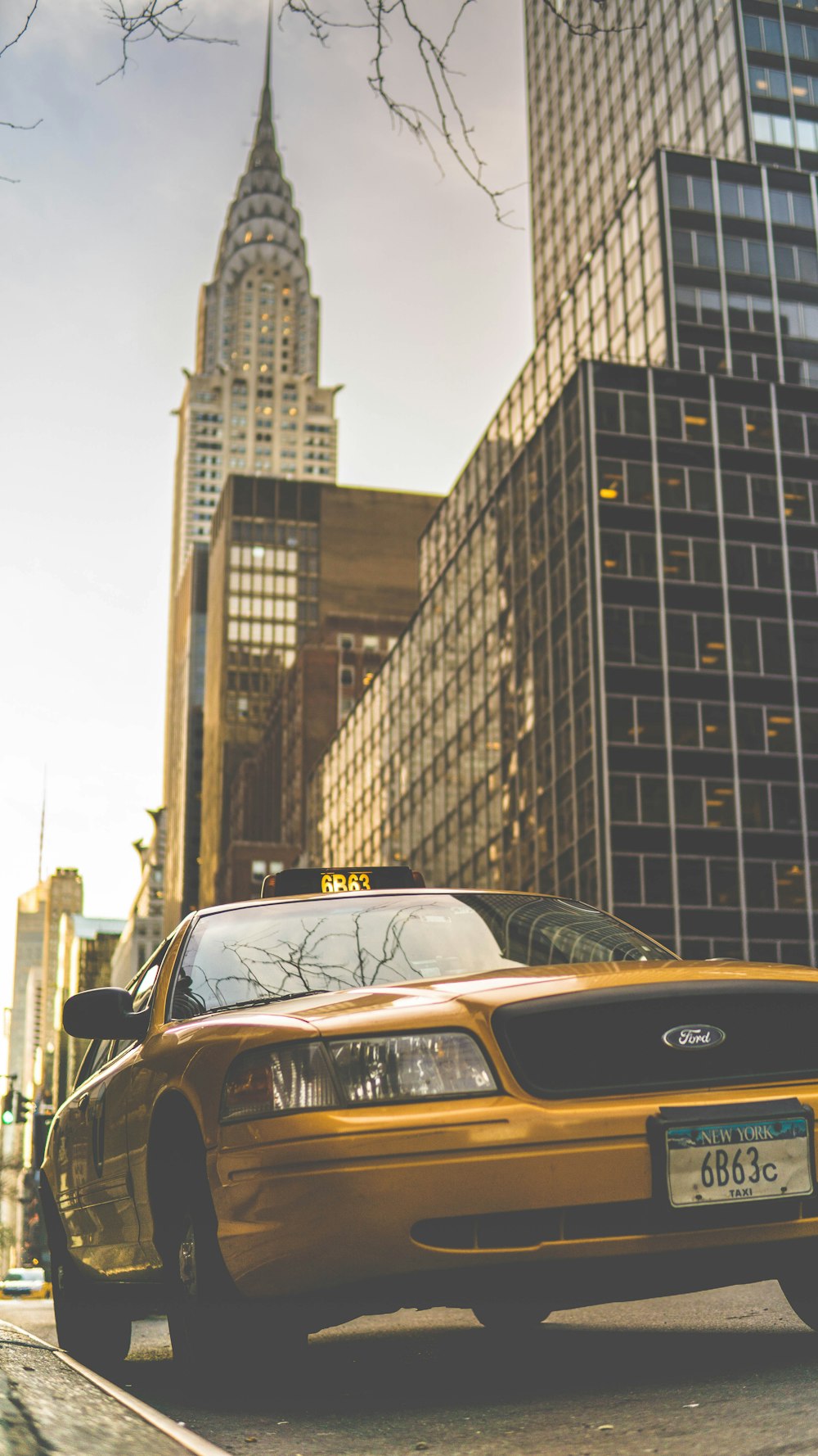 Taxi Ford amarillo estacionado cerca del edificio Chrysler