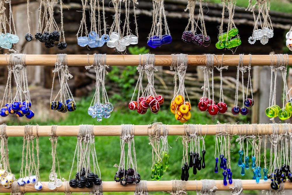 assorted-color bead accessory lot hanged on brown wooden bars