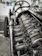 Close-up of a sleek BMW engine being carefully inspected by a technician in a modern workshop.