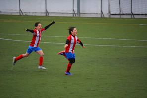 Children playing soccer joyfully on a sunny community field