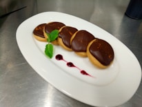 An elegant dessert plate featuring assorted gourmet cookies, garnished with fresh herbs.