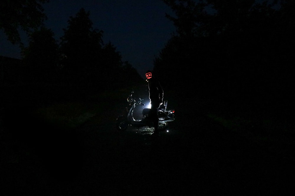 a person sitting on a motorcycle in the dark