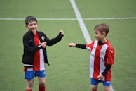 Children laughing and playing together during a friendly match on the club field