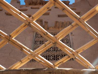 Artisan weaving bamboo strips into a custom-sized blind.