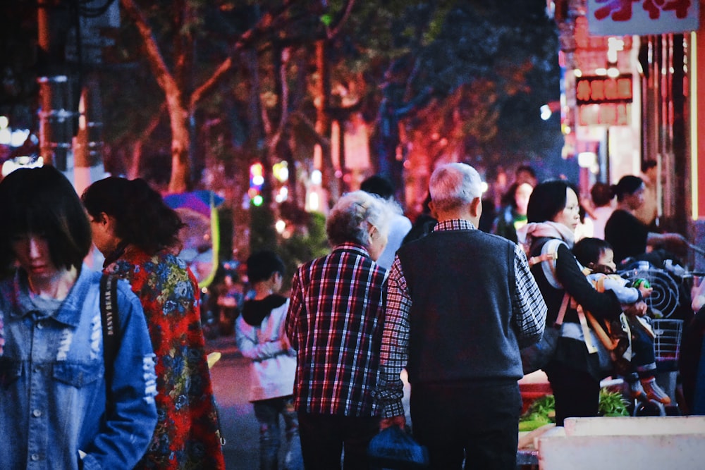 people walking on road near buildings during night