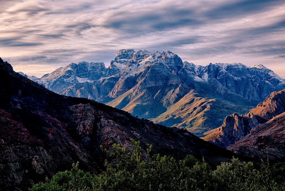 a view of a mountain range with trees in the foreground