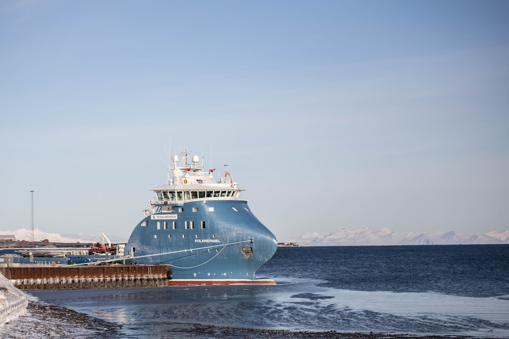 white and blue ship on sea