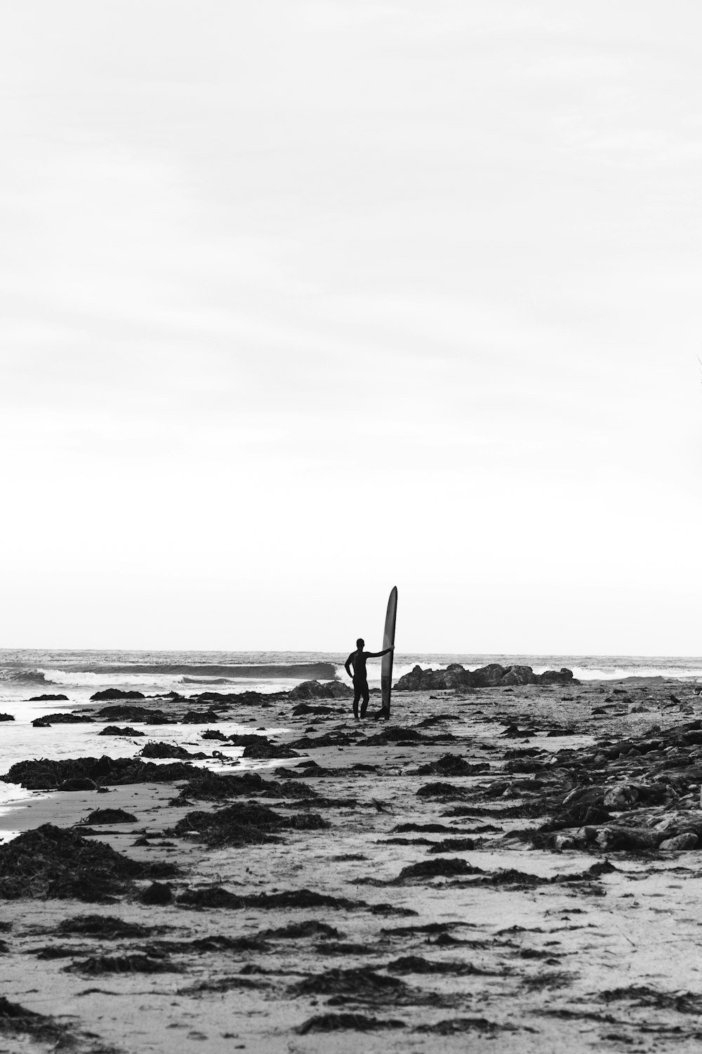 person holding surfboard near body of water