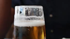 Close-up of frosty craft beer glasses with foam on top.