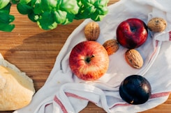 two apples and walnuts on white towel