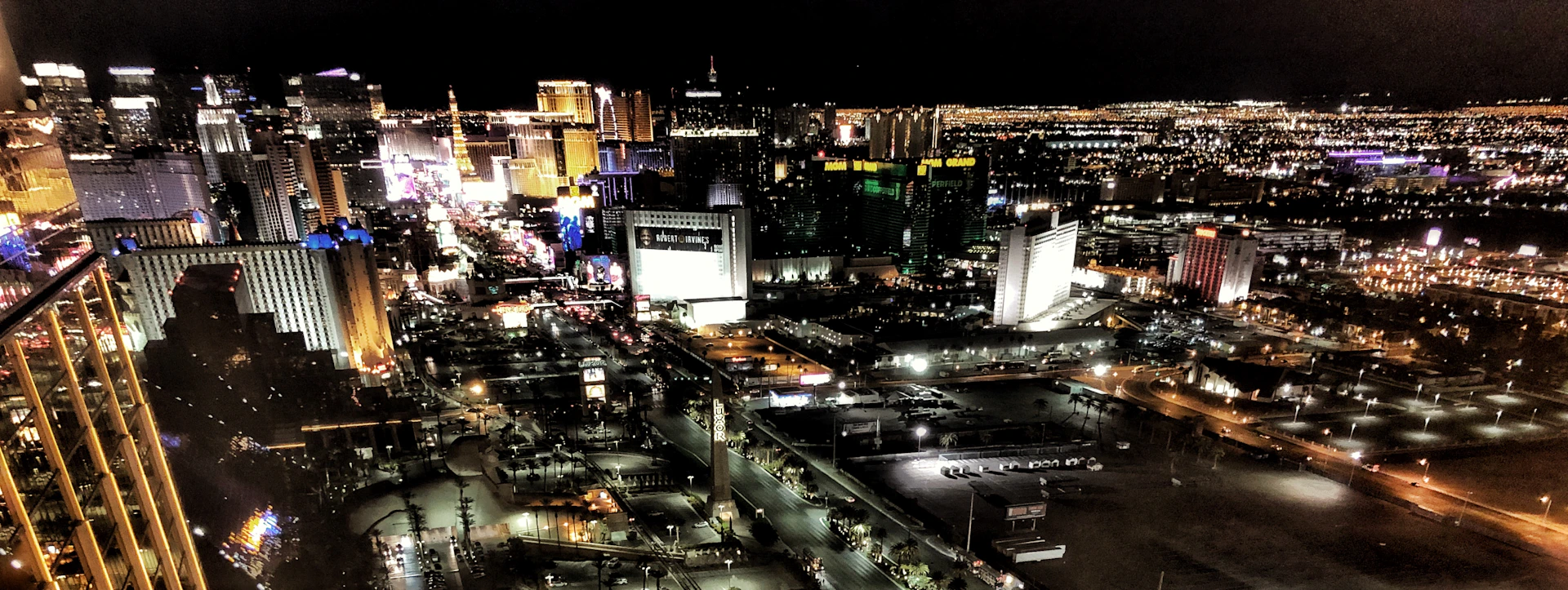 A panoramic view of a bustling city skyline at night, illuminated with colorful lights, inviting visitors to explore urban adventures.