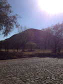 Golden sunlight casting long shadows over the Kukulkan Pyramid at Chichen Itza.