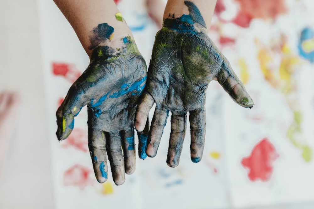 mãos de pessoa com tinta verde