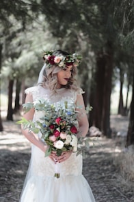 woman wearing white wedding dress holding flower bouquet