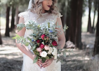 woman wearing white wedding dress holding flower bouquet