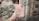A hand is holding a transparent water bottle with a red cap and a circular red handle. The bottle features motivational text that reads 'Do your Best!!!' in bold red letters. In the background, there are blurred green leaves and part of a building with small square lattice openings.