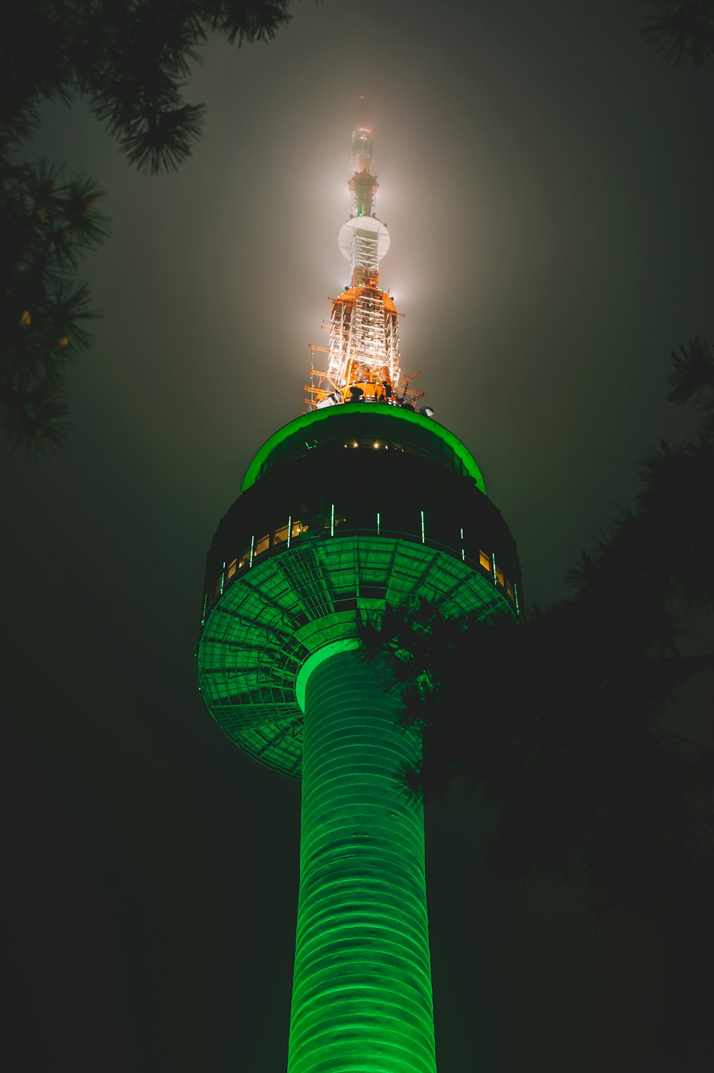 Eingeschalteter grün-weiß beleuchteter Turm in der Nacht