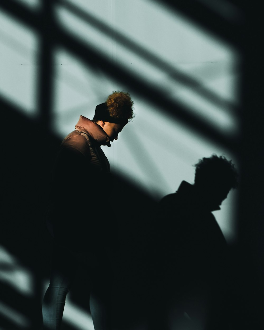 a man standing in front of a window next to a shadow