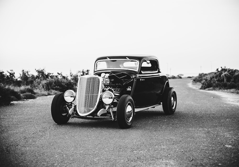 Photographie en niveaux de gris d’une voiture classique vintage