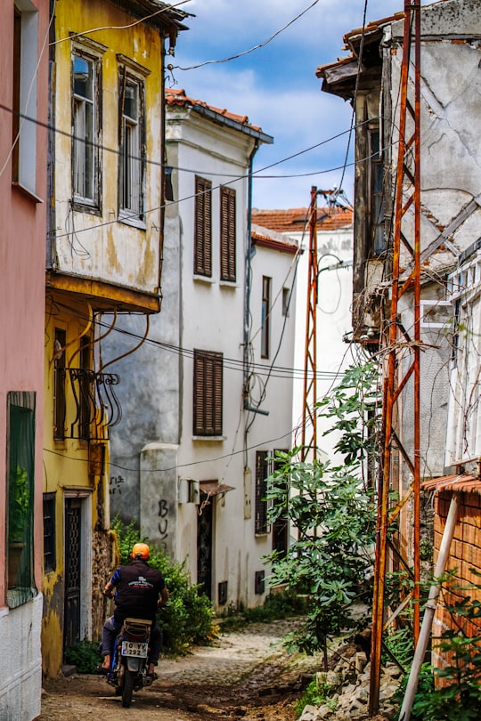 man riding motorcycle near yellow house in Ayvalık Turkey