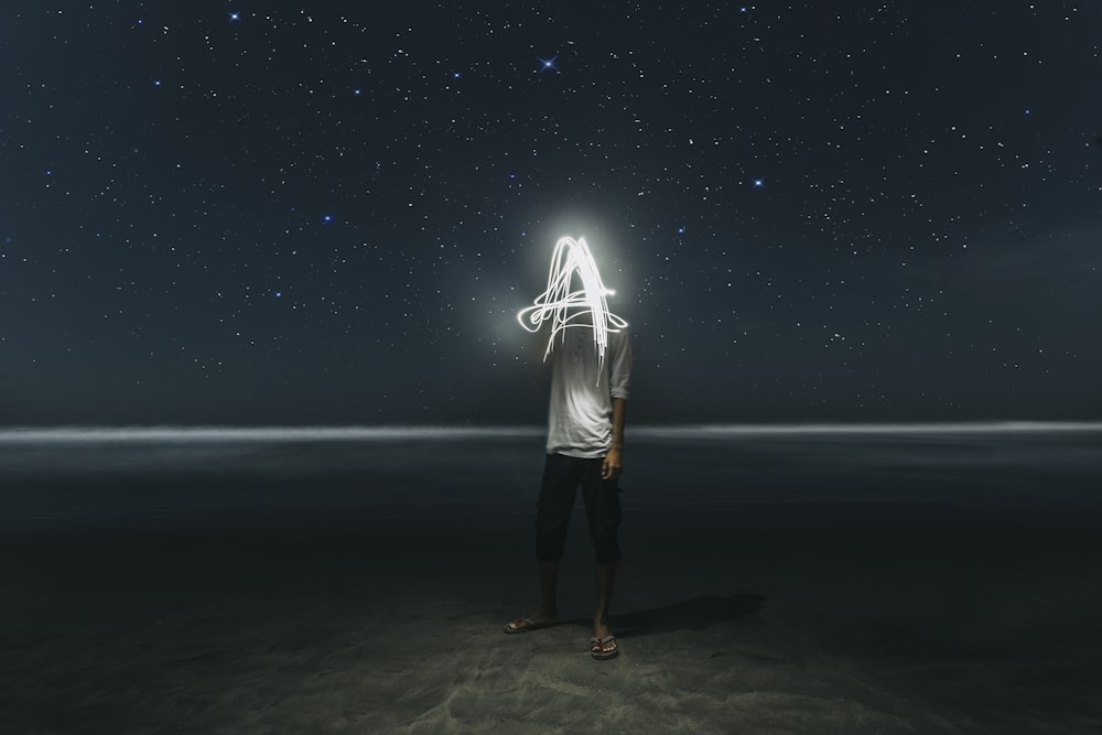 man standing on seashore at night