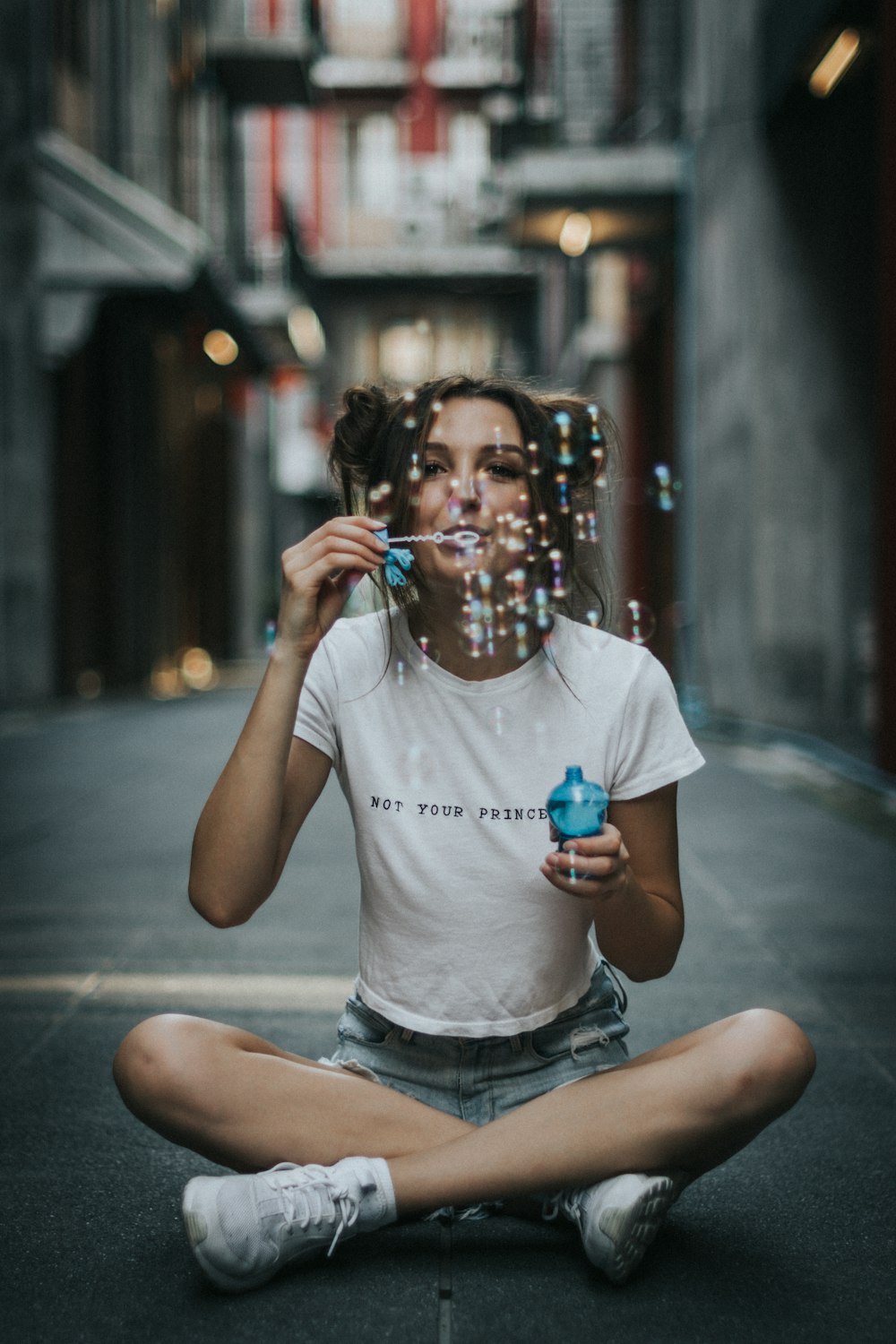 woman sitting blowing bubbles