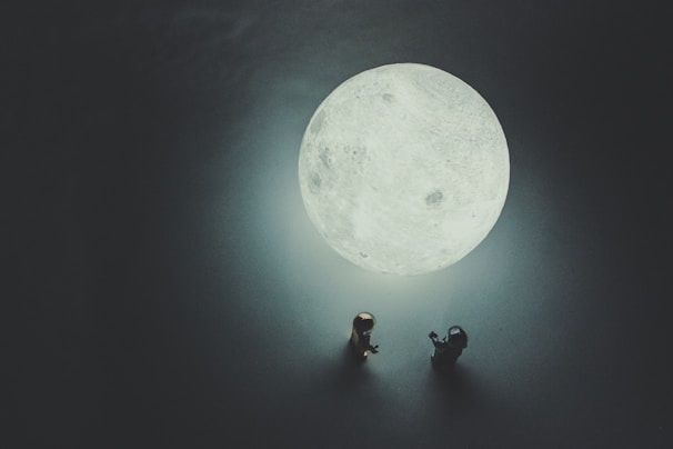 A scene featuring several awkward, blurred creatures interacting under a glowing moon.