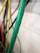 Several colorful cables are shown with green, red, yellow, and black colors prominently visible. The green cable is in focus, while the others are blurred in the background.