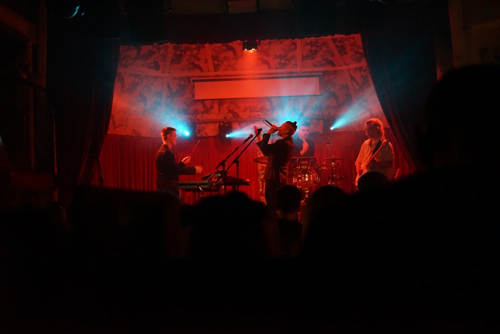 photo of man holding microphone while standing at the stage