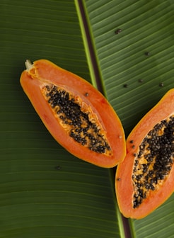 sliced papaya on green banana leaf