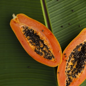 sliced papaya on green banana leaf