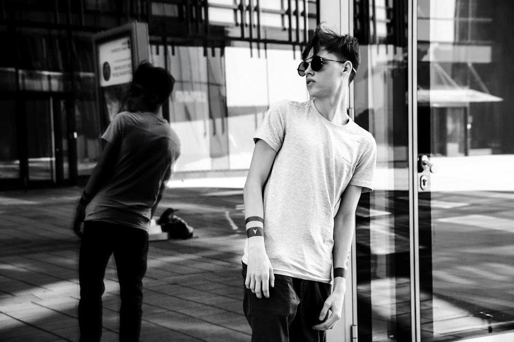 man leaning on glass wall while looking on his right side