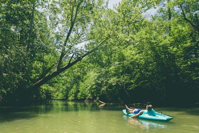 A serene kayak gliding along the calm waters of the Niagara River surrounded by lush greenery.