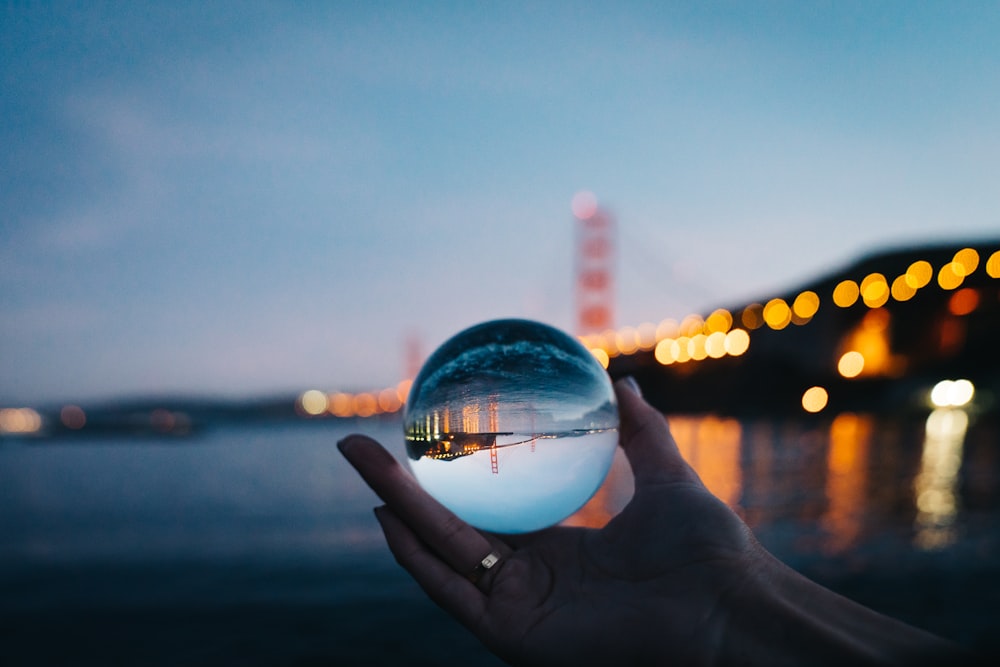 person holding glass ball