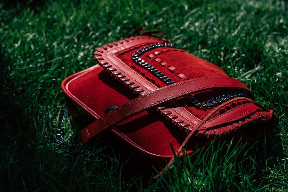 red leather handbag on grasses