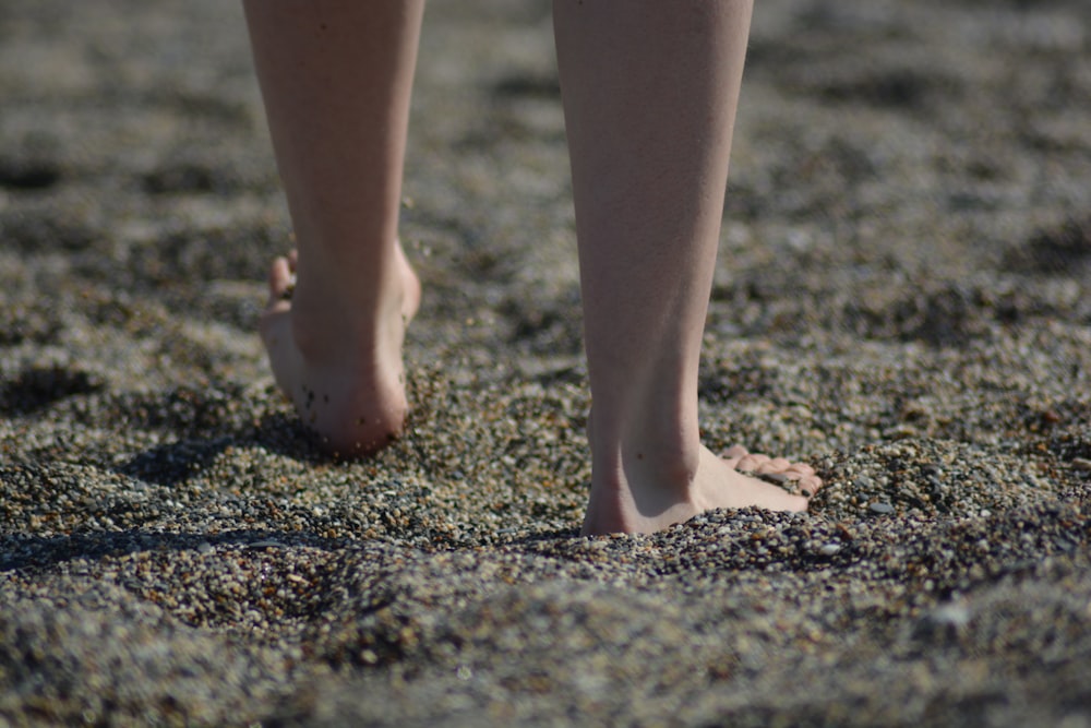 person standing on brown sand