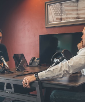 man sitting in front of another man also sitting inside room