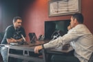 man sitting in front of another man also sitting inside room