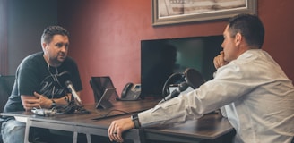 man sitting in front of another man also sitting inside room