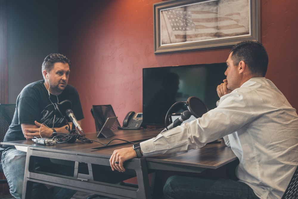 man sitting in front of another man also sitting inside room