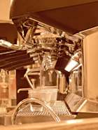 Display of various coffee machines suited for bars and restaurants with warm cream and brown tones
