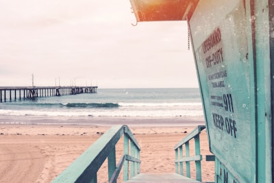 teal wooden lifeguard shed near seashore